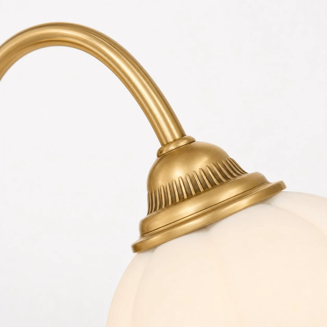 Close-up of brass arm and glass shade connection