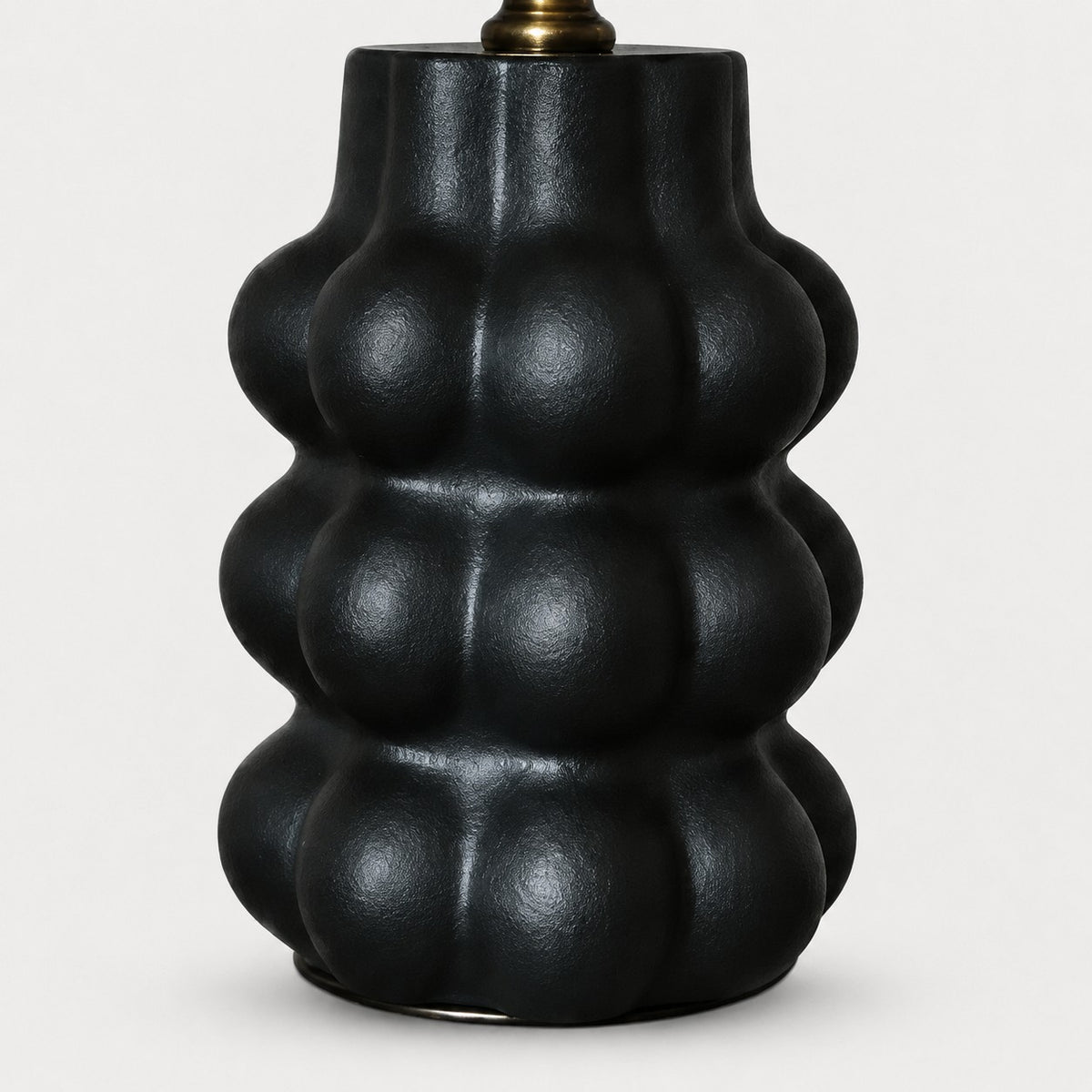 Sculpted matte black ceramic lamp base detail