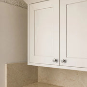 Titanium silver knobs on white cabinet doors