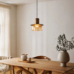 Cargar imagen en el visor de la Galería, Amber brass glass pendant light above a wood dining table