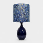 Afbeelding laden in galerijweergave, Blue gold patterned fabric ceramic table lamp on plain background