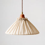 Load image into Gallery viewer, Front view of natural linen pleated pendant light with wood socket cover and twisted cord