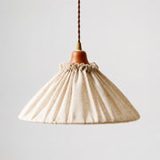 Front view of natural linen pleated pendant light with wood socket cover and twisted cord