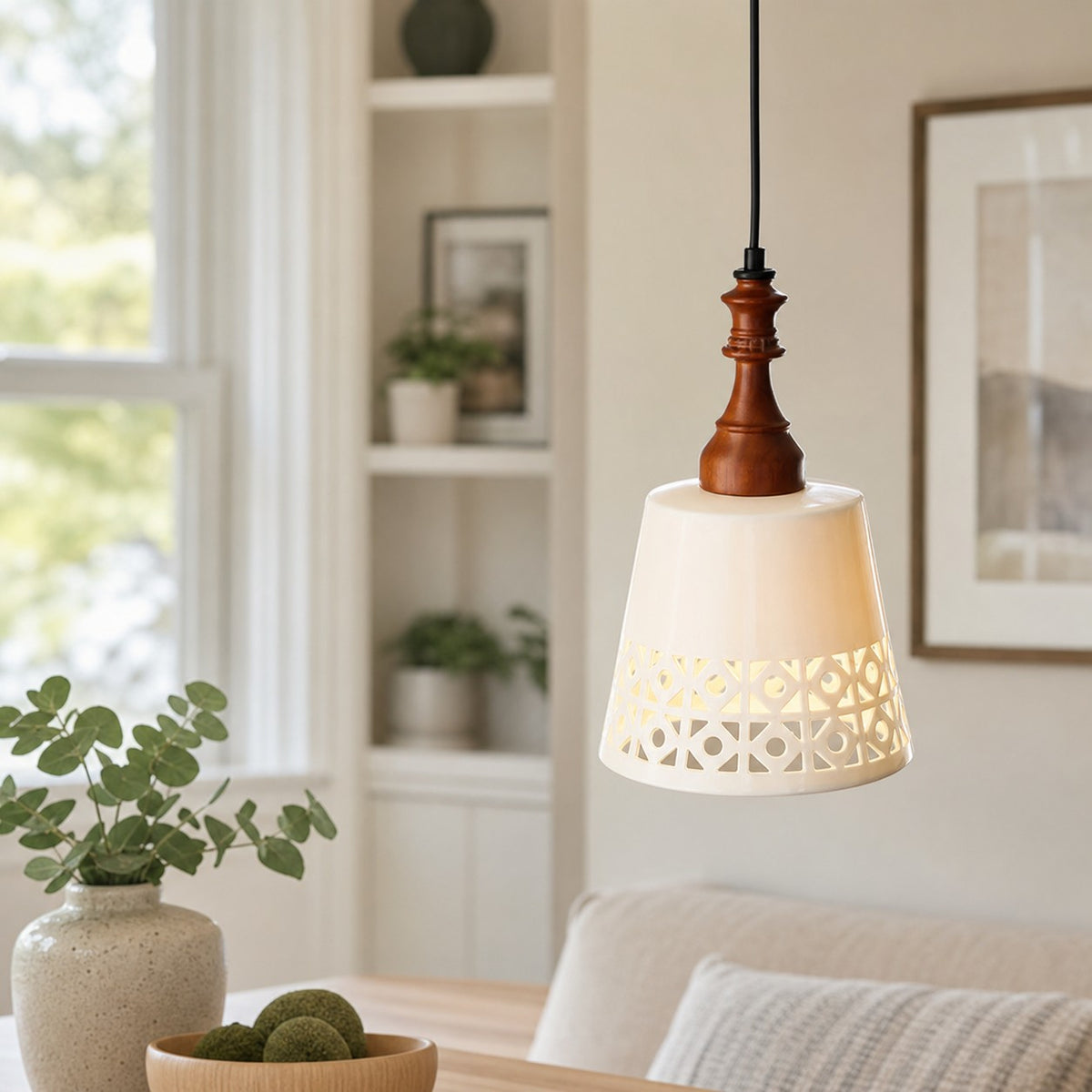 cream ceramic cutout pendant light beside a window