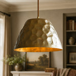 Cargar imagen en el visor de la Galería, Hammered brass pendant light hanging in a warm living room interior
