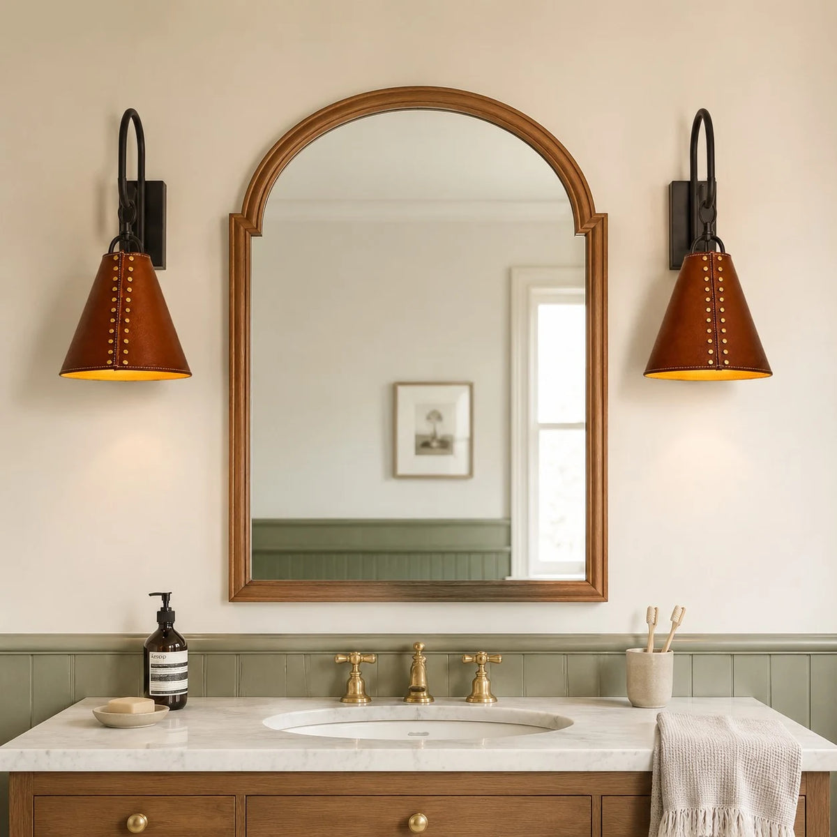 Pair of black and red leather wall sconces installed beside a bathroom mirror