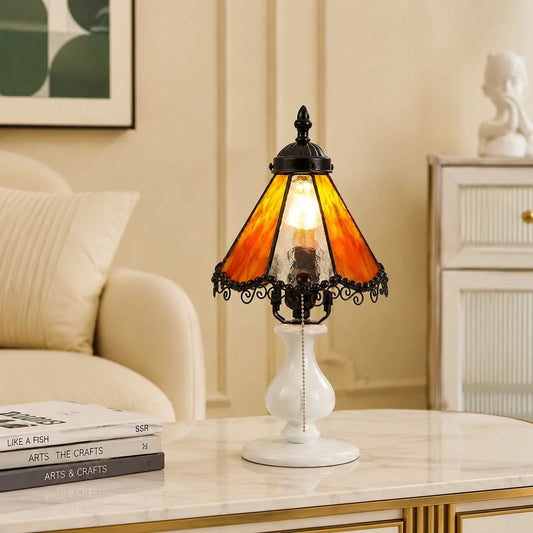 Orange stained glass table lamp styled on a bedside table in a cream bedroom