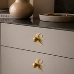 Afbeelding laden in galerijweergave, Antique brass swallow handles on a neutral dresser