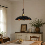 Cargar imagen en el visor de la Galería, black cowhide pendant light casting warm light over a rustic table