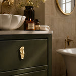 Load image into Gallery viewer, Abstract brass face cabinet knob on a dark green bathroom drawer