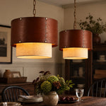 Cargar imagen en el visor de la Galería, Brown leather drum shade pendants above a dining table