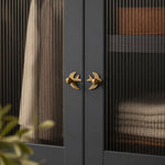 Afbeelding laden in galerijweergave, Mirrored antique brass swallow handles on a dark cabinet
