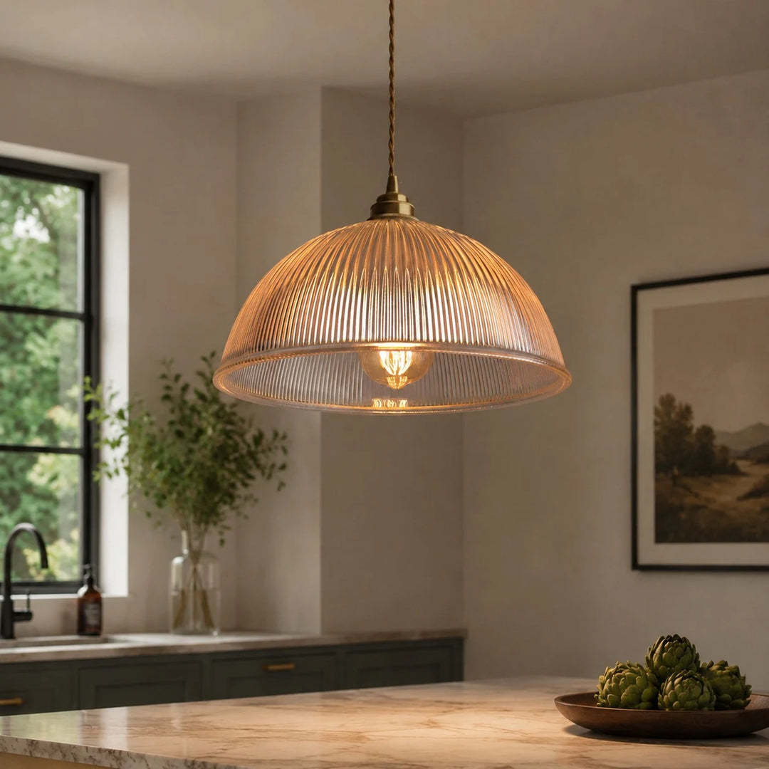 Clear ribbed glass pendant light glowing in a warm kitchen scene