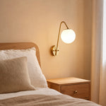 Cargar imagen en el visor de la Galería, Brass glass globe wall light styled beside a bedroom wall