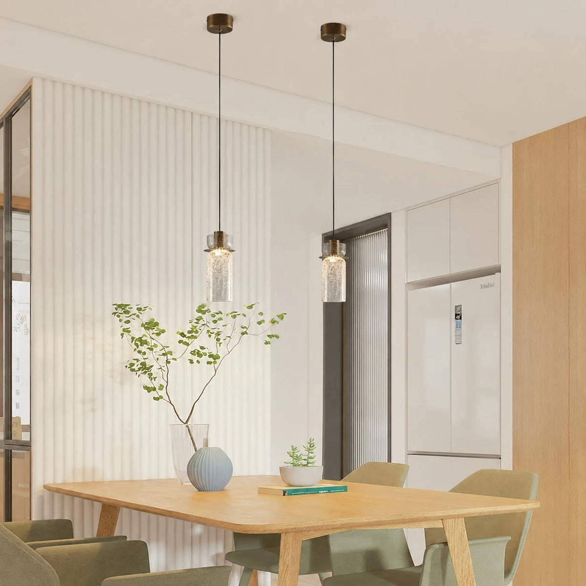 Pair of brass glass pendant lights installed above a kitchen dining table