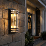 Carica l'immagine nella visualizzazione Galleria, Medium bronze glass outdoor wall sconce glowing on a stone exterior wall