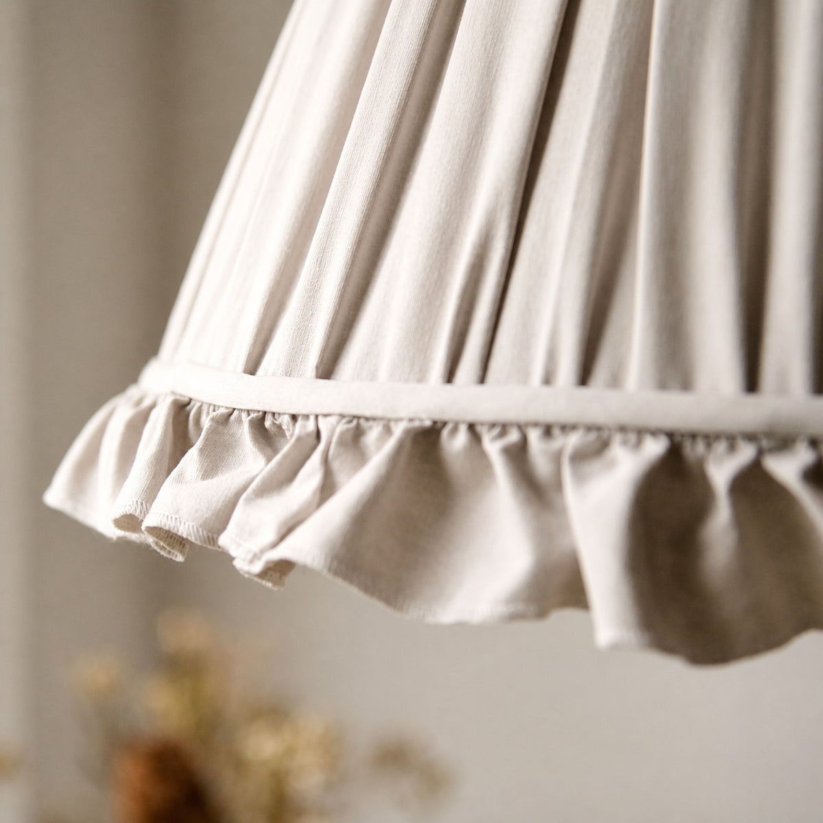 Close view of the pleated fabric shade and scalloped trim