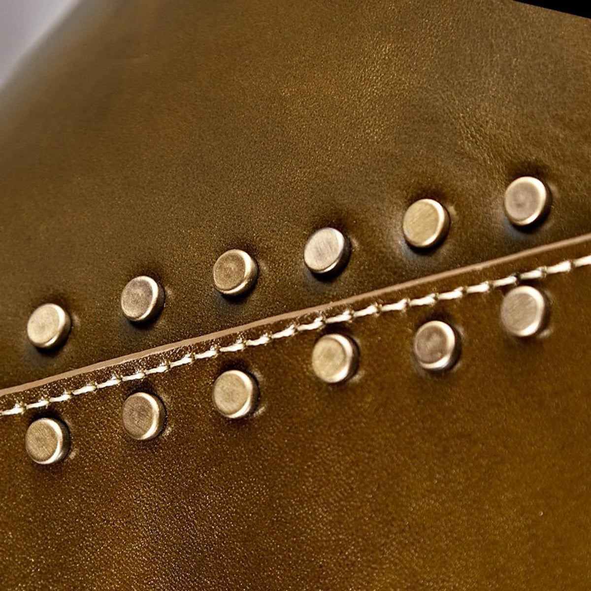 Close detail of brown leather shade with gold rivets