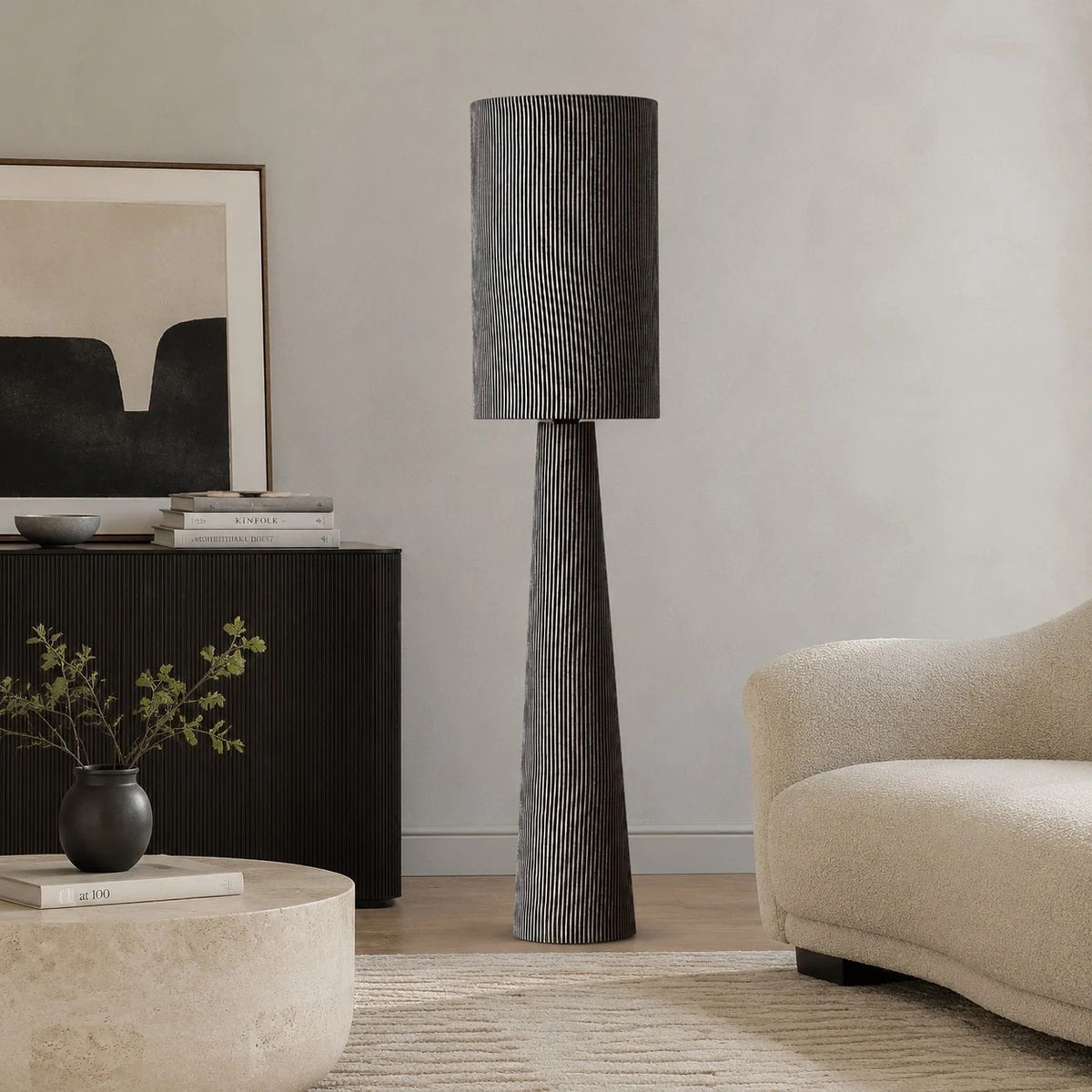 Gray striped floor lamp near a console and lounge chair