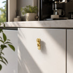 Load image into Gallery viewer, Abstract brass face cabinet knob on white kitchen cabinetry